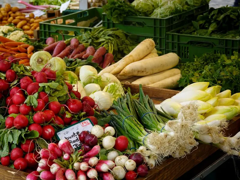 A market stall piled with radishes and chicory